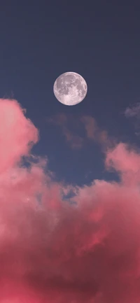 Pleine lune illuminant des nuages cumulus roses