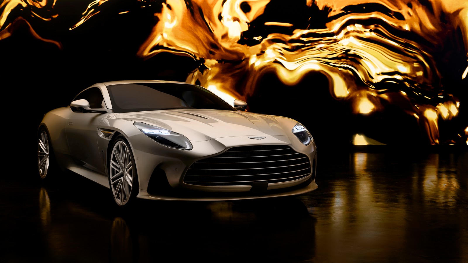 Un primer plano de un coche plateado frente a una pantalla grande (aston martin db12, goldfinger edition, 2024, 5k, 8k)