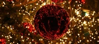 Festliche rote Ornamente, beleuchtet von Weihnachtslichtern