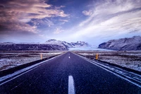 Camino sereno a través de montañas cubiertas de nieve en Islandia