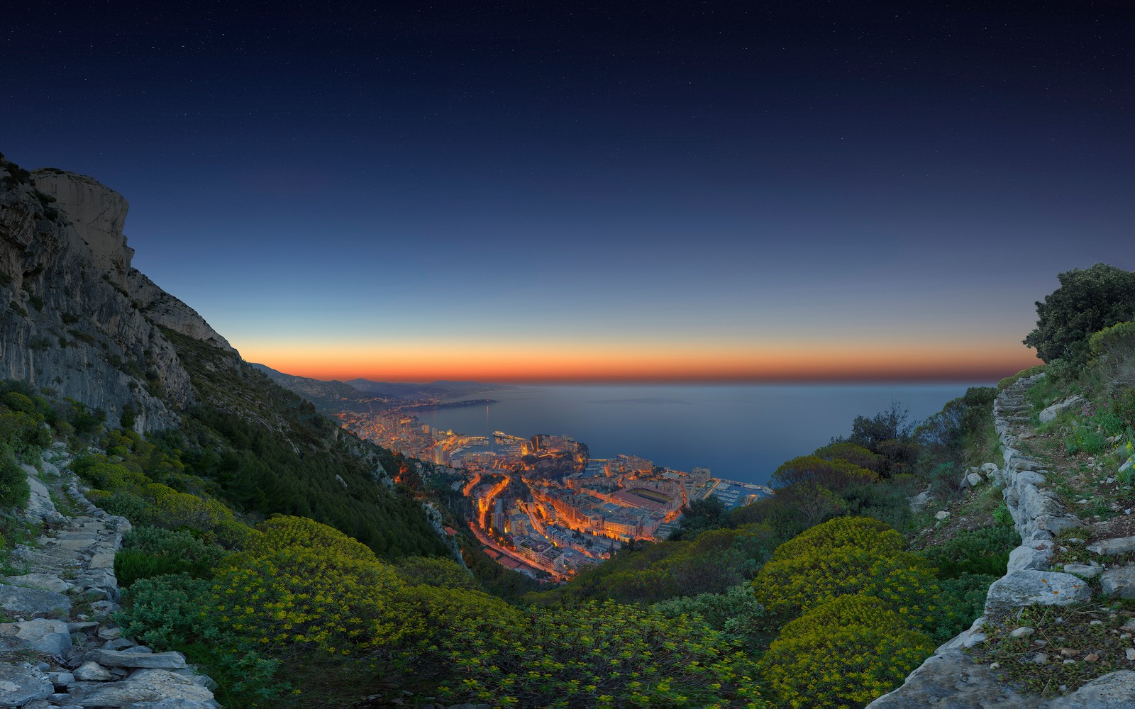 Uma vista de uma cidade de um penhasco ao pôr do sol (paisagem, água, nuvem, planta, ecorregião)