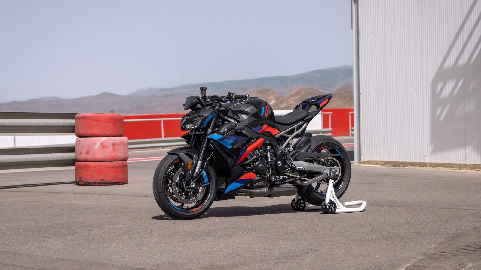 Arafed motorcycle parked in front of a building on a road (bmw m 1000 r m competition, 2024, 5k, sports bikes, bmw m 1000 r)