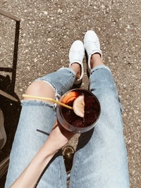 Casual Outdoor Style: White Sneakers and Refreshing Drink