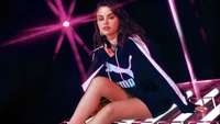 Selena Gomez en un atuendo elegante de Puma, irradiando confianza contra un fondo vibrante.