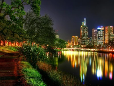 Paisagem urbana de Melbourne à noite: Reflexões no rio