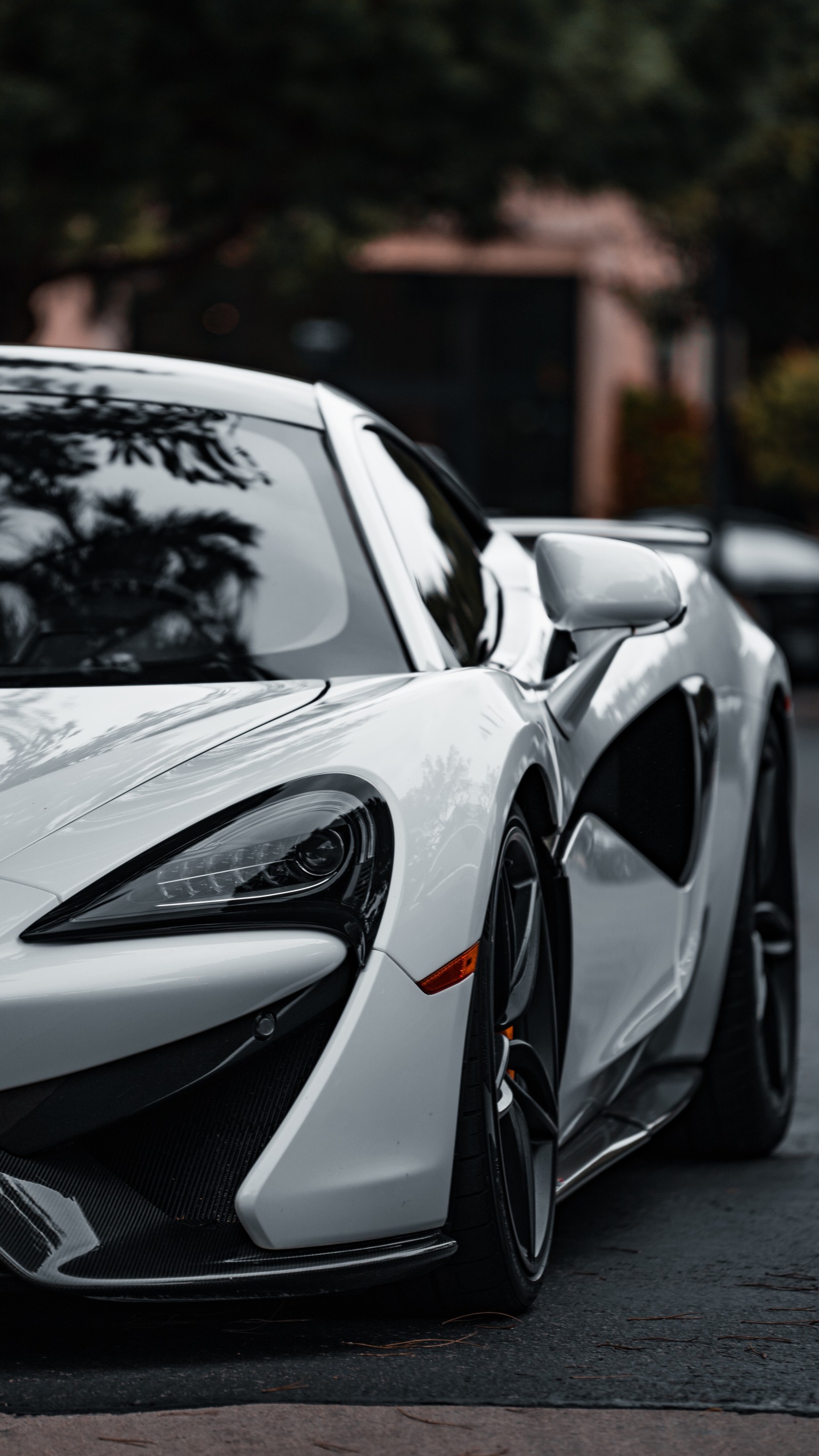 A close up of a white sports car parked on a street (rim, nissan skyline, mid size car, cars, headlamp)