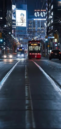 Nächtliche städtische Szene mit gemischt genutzten Gebäuden, Straßenbahn und Autoverkehr