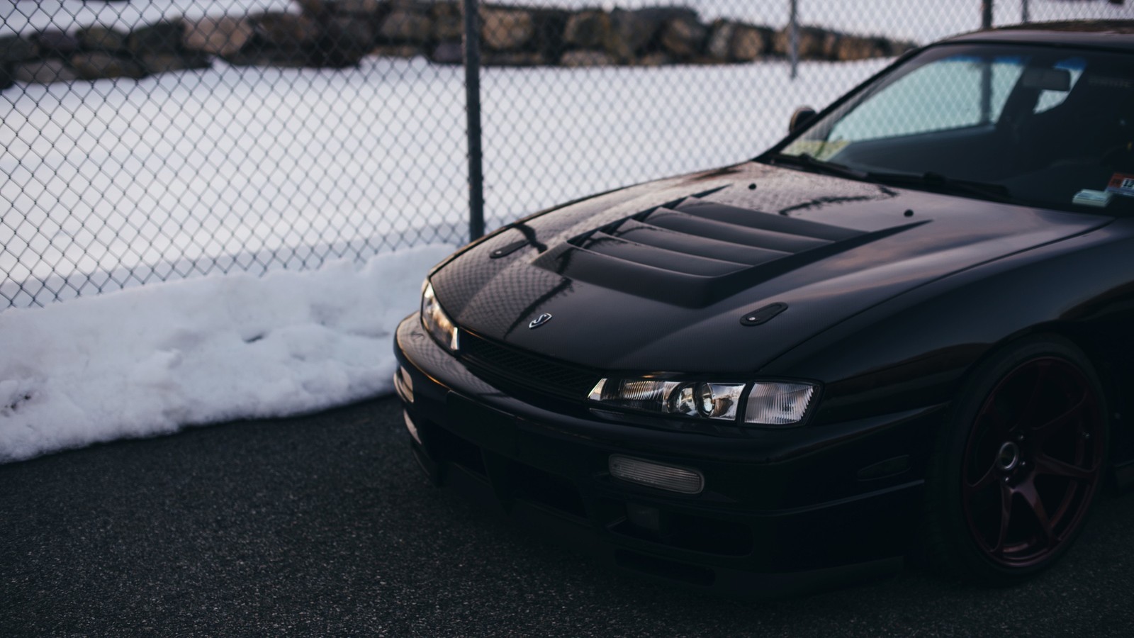 Arafed schwarzes auto, das vor einem zaun im schnee geparkt ist (nissan silvia, auto, nissan 180sx, sportwagen, kapuze)