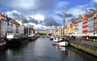 Colorido paseo marítimo del canal de Copenhague con barcos históricos y arquitectura encantadora