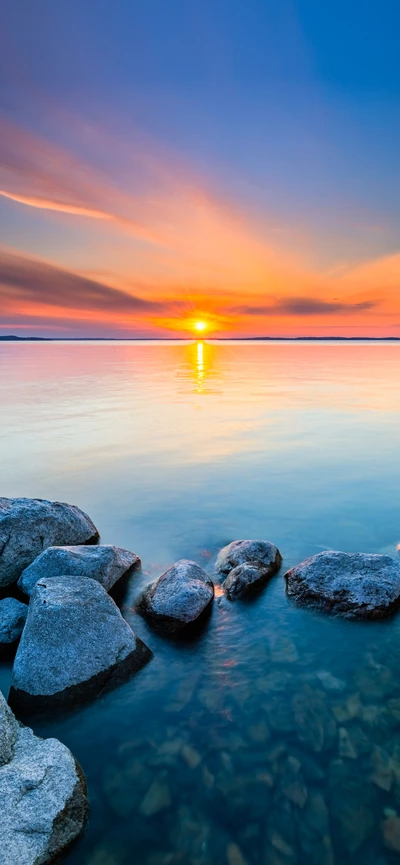 Sérénité du crépuscule : Une réflexion tranquille du coucher de soleil au bord de l'eau