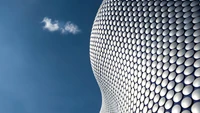 Arquitectura moderna simétrica del edificio Selfridges contra un cielo azul claro