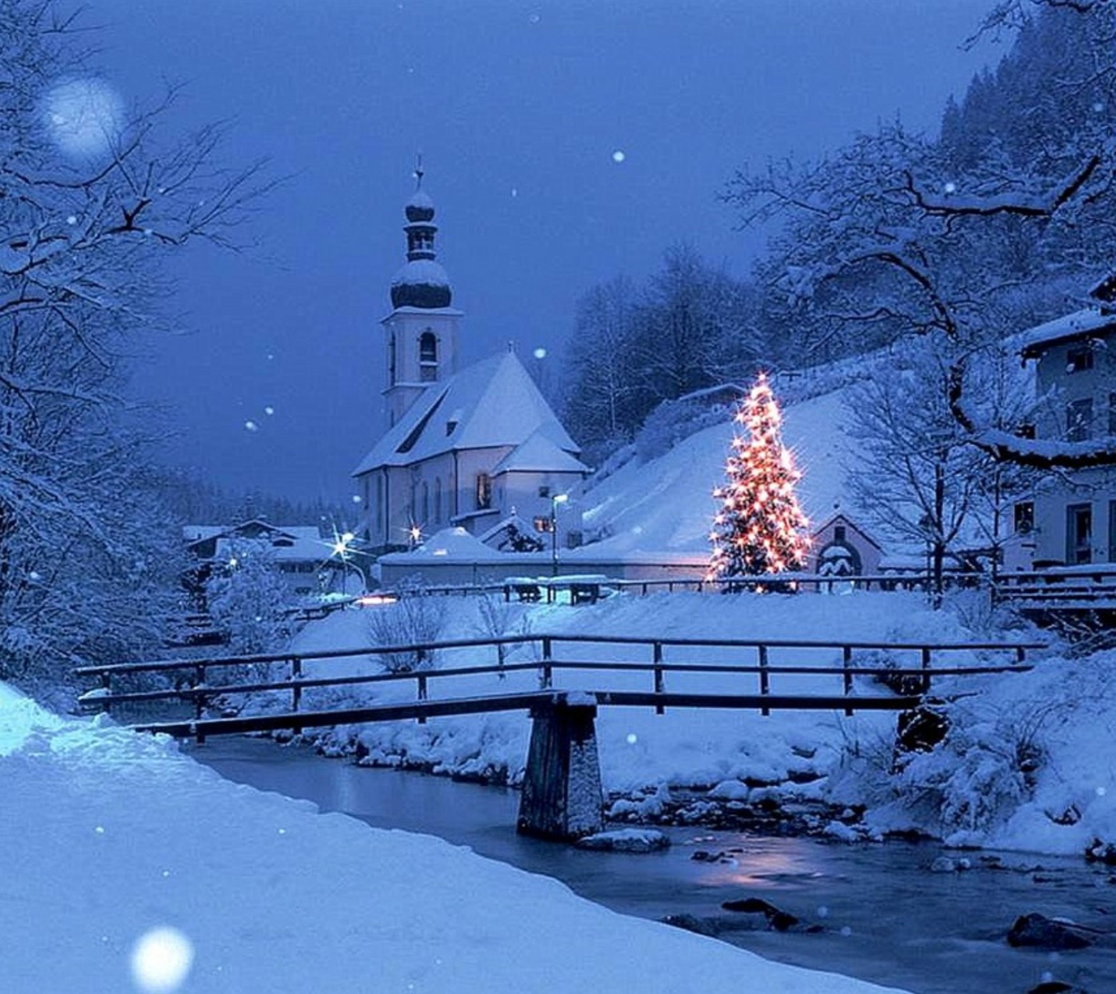 Schneebedeckte szene einer kleinen stadt mit einer brücke und einem beleuchteten weihnachtsbaum (landschaft, natur, winter)