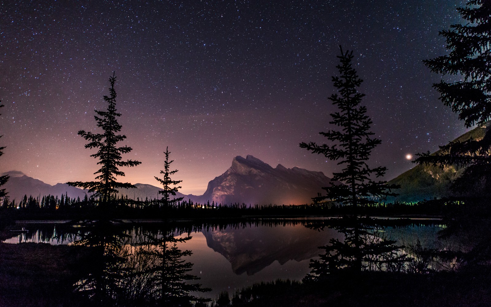 Uma vista de um lago com árvores e uma montanha ao fundo (mount rundle, paisagem noturna, parque nacional de banff, banff national park, reflexo)