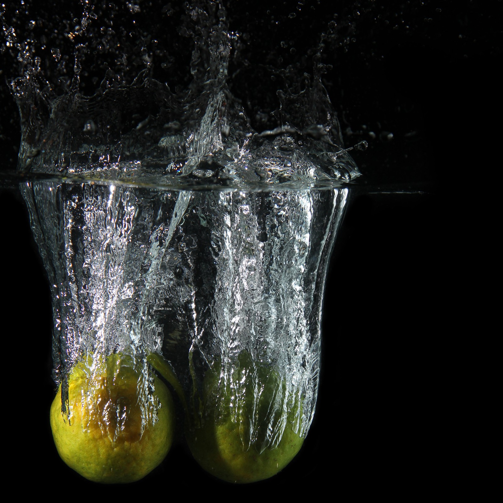 There are two lemons in the water with a splash of water (fruits, photography)