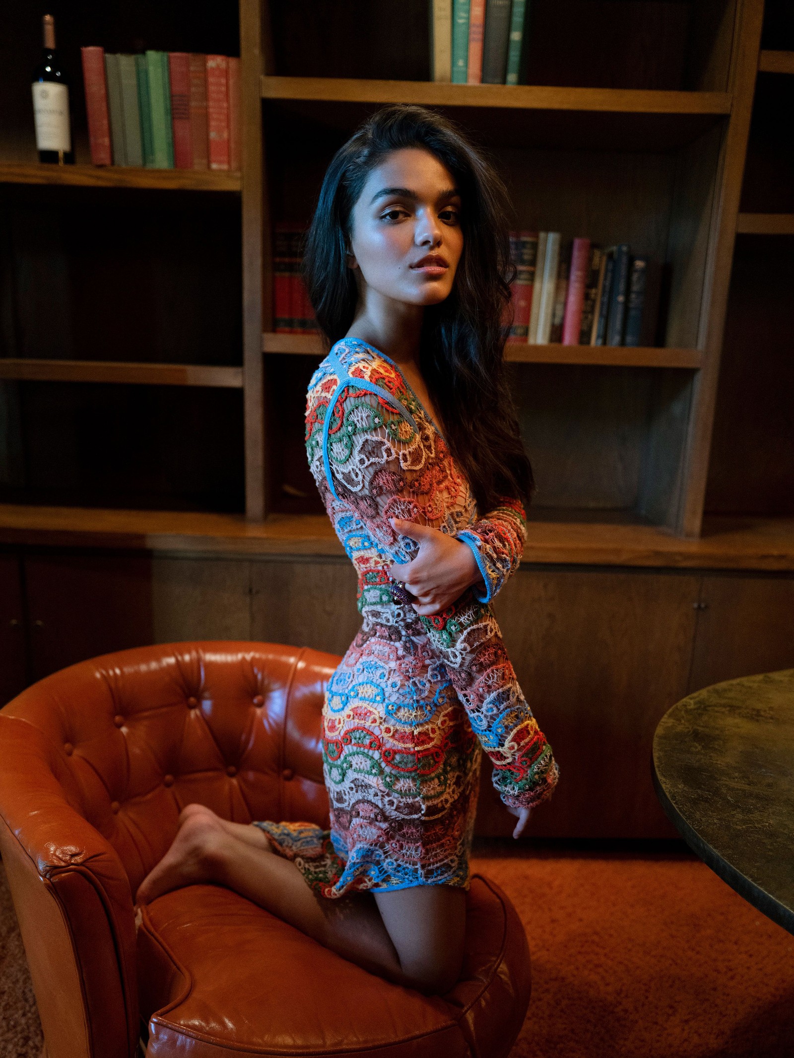 Une femme en robe colorée assise sur une chaise dans une bibliothèque (rachel zegler, actrice américaine, gens, fond décran 4k)