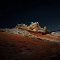 Noite estrelada no deserto sobre formações rochosas sedimentares