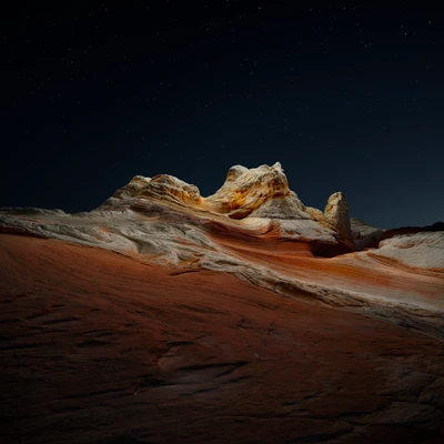 Noche estrellada en el desierto sobre formaciones rocosas sedimentarias