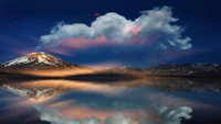 Réflexion tranquille d'un volcan enneigé sous un ciel dramatique