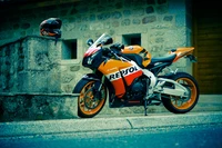 Moto Repsol Honda CBR1000RR garée avec un casque à proximité