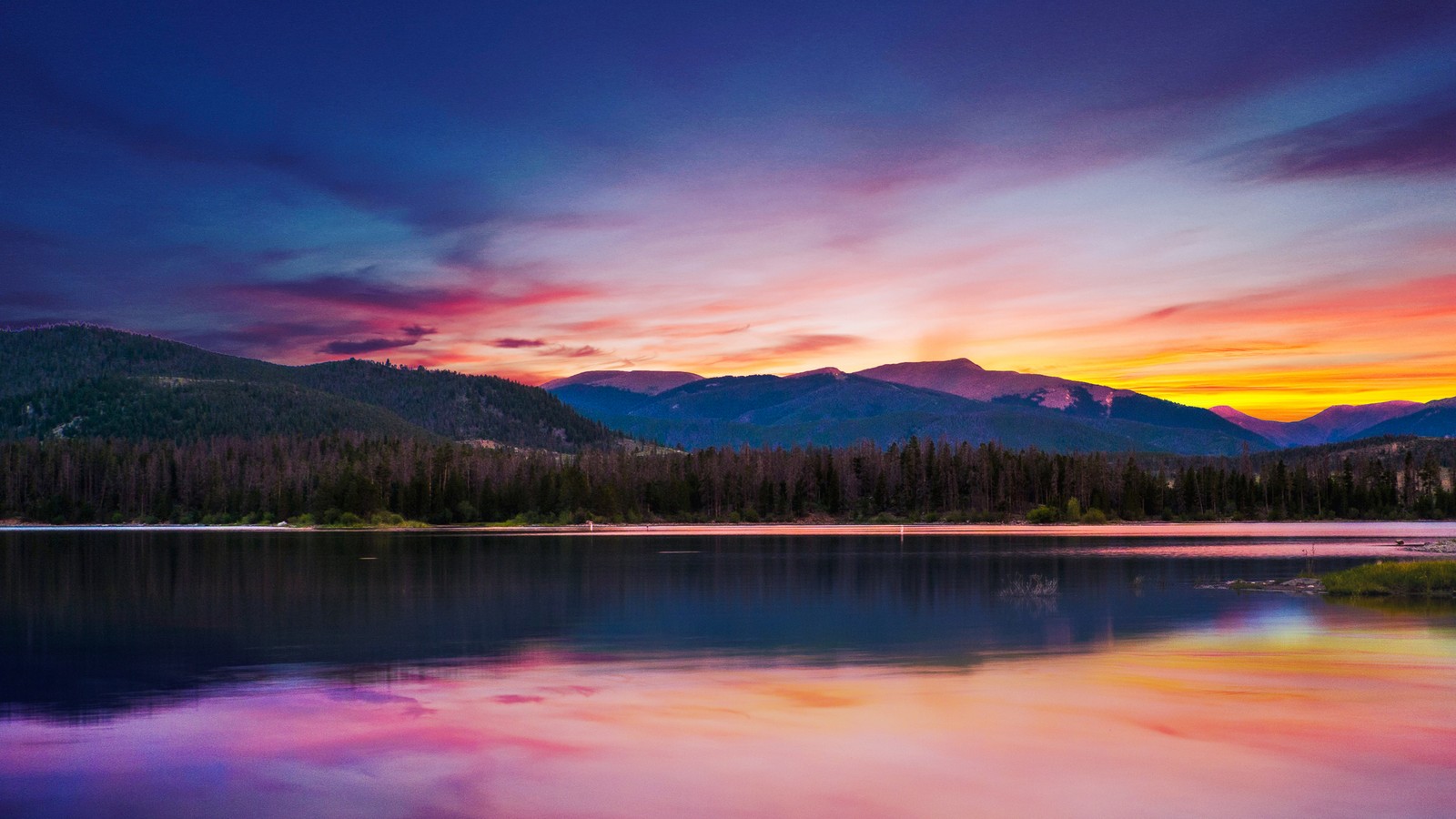 Un beau coucher de soleil sur un lac de montagne avec un ciel coloré (coucher de soleil, forêt, montagnes, flueve, plan deau)