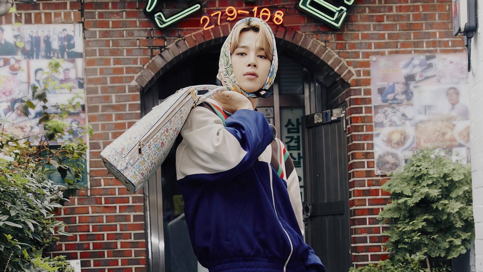 Há uma mulher caminhando na rua carregando uma bolsa (jimin, 지민, park ji min, 박지민, bts)