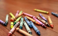 A colorful assortment of crayons scattered on a wooden surface.