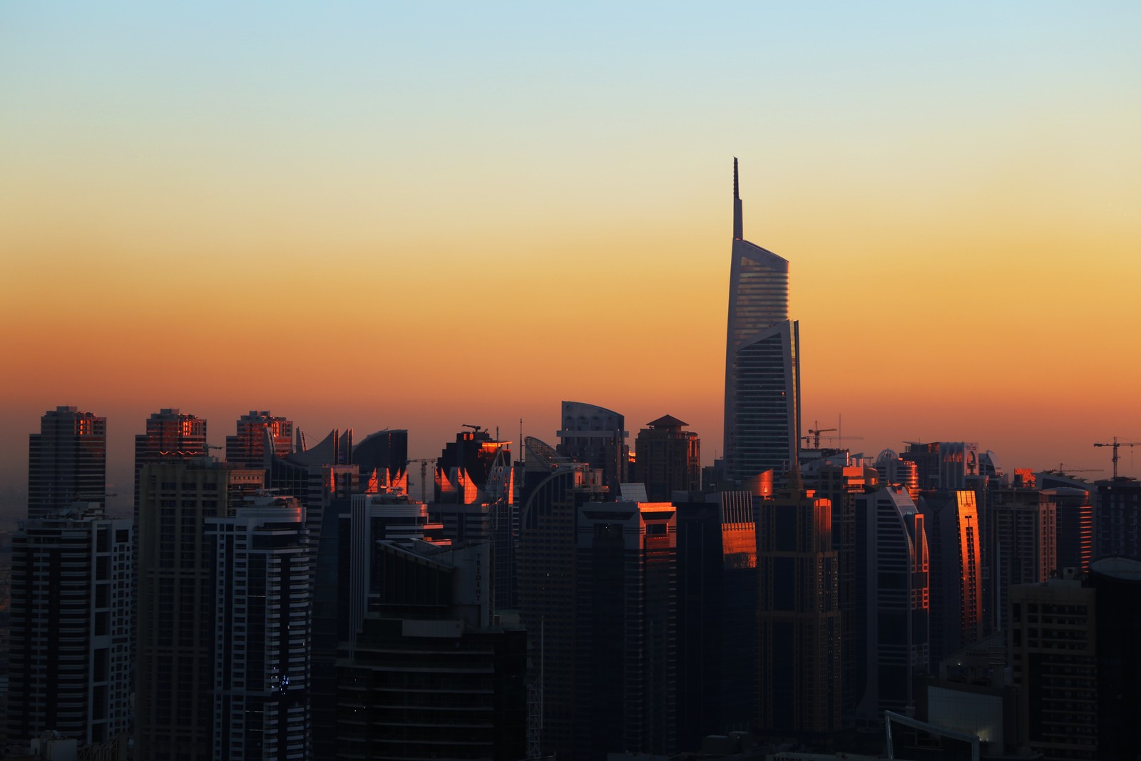 Silhouette arabe d'un skyline urbain au coucher du soleil avec un avion survolant (paysage urbain, zone urbaine, ville, horizon, manhattan)