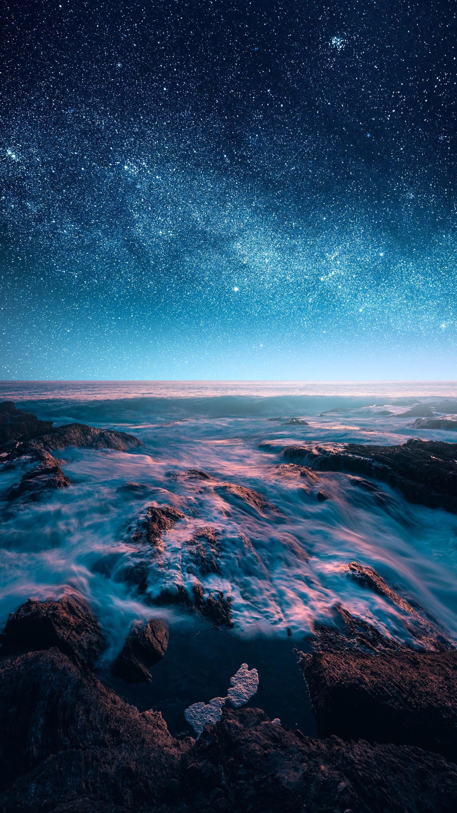 Céu noturno estrelado sobre o oceano com rochas e água (desenho, água, atmosfera, recursos hídricos, paisagem natural)