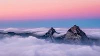 Montanhas majestosas acima de um mar de nuvens ao amanhecer