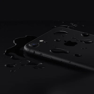 iPhone noir avec des gouttes d'eau sur un fond sombre