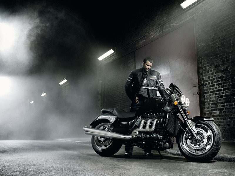 Человек сидит на мотоцикле в темной комнате (triumph motorcycles ltd, triumph rocket iii, мотоцикл, крейсер, автомобильная шина)