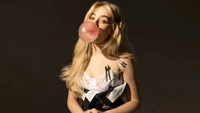 Sabrina Carpenter soprando chiclete em uma ousada sessão de fotos para a Rolling Stone