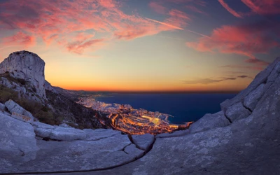 Monaco Stadt bei Sonnenaufgang: Ein atemberaubender Panoramablick über Klippen und Felsen, getaucht in sanftes Morgenlicht und lebendige Wolken.