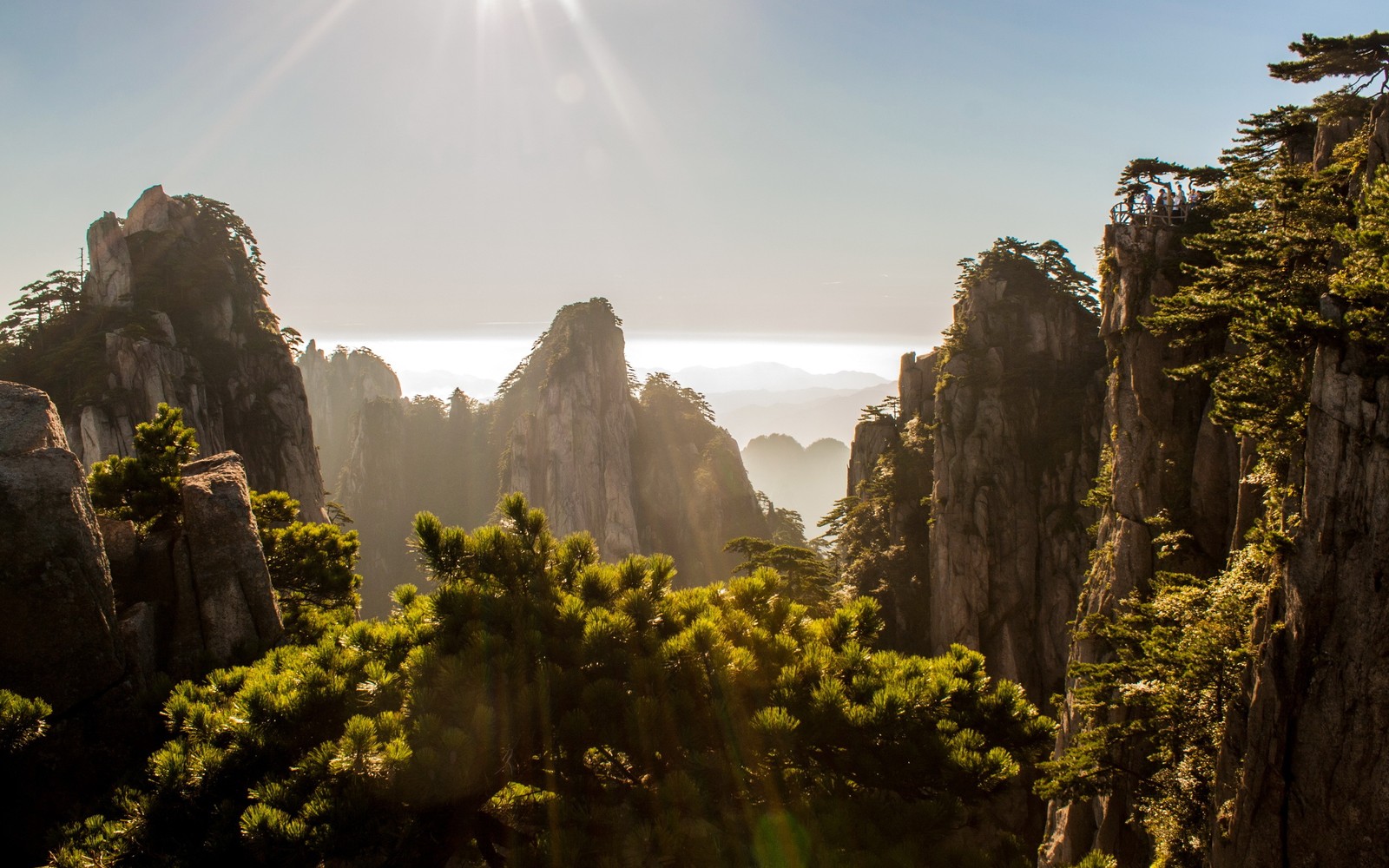 Vista de una cordillera con el sol brillando sobre las montañas (naturaleza, vegetación, roca, desierto, reserva natural)