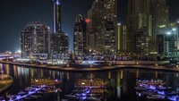 Illuminated Urban Skyline Reflecting on Water at Night with Skyscrapers and Boats