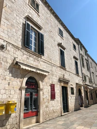 Fachada de ladrillo histórico con ventana y puerta arqueadas