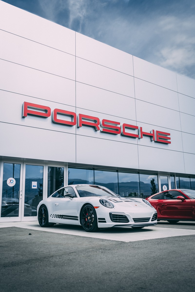 Автосалон porsche с двумя машинами припаркованными перед ним (porsche, машина, спортивный автомобиль, суперкар, колесо)