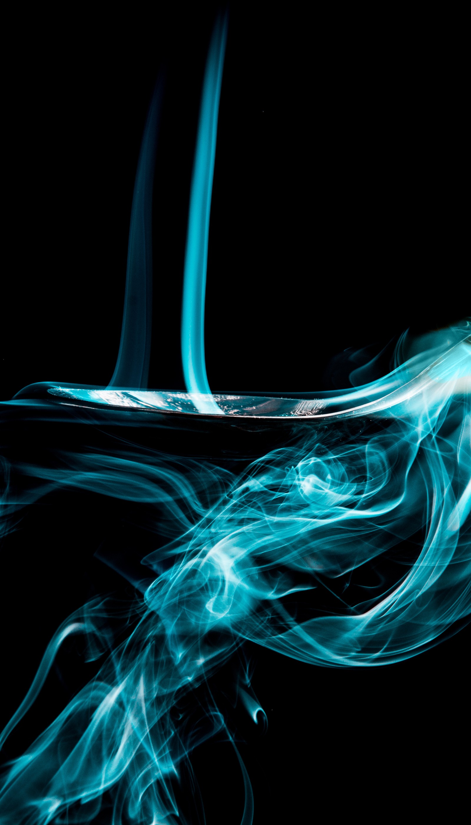 Smoke is swirling in the air on a black background (abstract, aqua, blue, smoke, spoon)