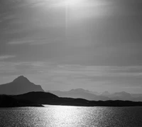 Paisaje en blanco y negro de las montañas noruegas contra una superficie de agua reflectante