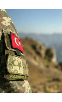 Türkische Militärinsignien auf Uniformen vor einer malerischen Landschaft