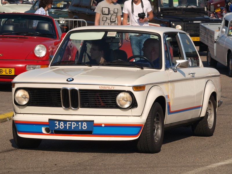 Bmw 2000-х на парковке с людьми, стоящими на автомобиле (bmw 2002tii, bmw, бмв новый класс, bmw new class, машина)