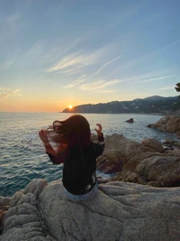 Sérénité du coucher de soleil : Une figure embrassant la nature au bord de la mer