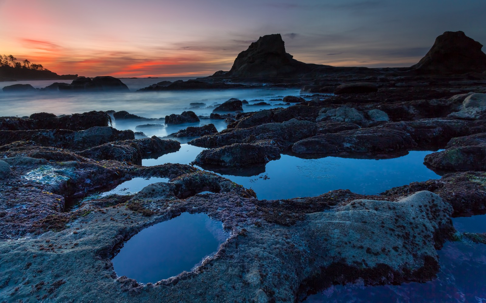 Une vue d'une plage rocheuse avec un coucher de soleil en arrière-plan (nature, mer, la côte, océan, roche)