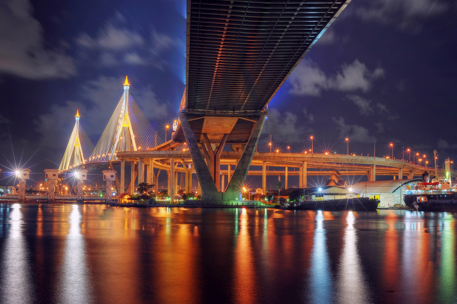 Vista árabe de un puente sobre un cuerpo de agua por la noche (puente, reflexión, puente atirantado, noche, hito)