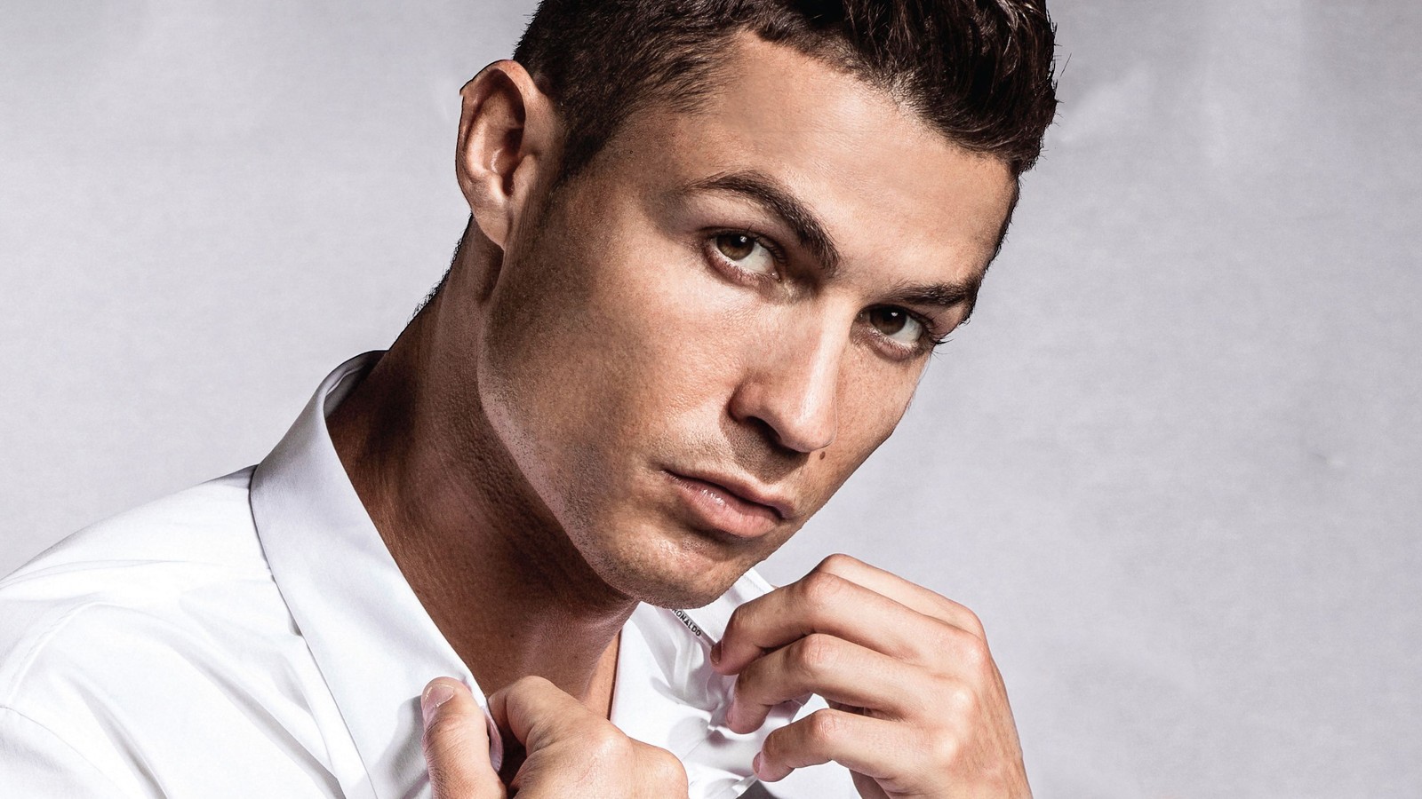 Крупный план мужчины, поправляющего галстук на белой рубашке (cristiano ronaldo, лицо, подбородок, щека, лоб)