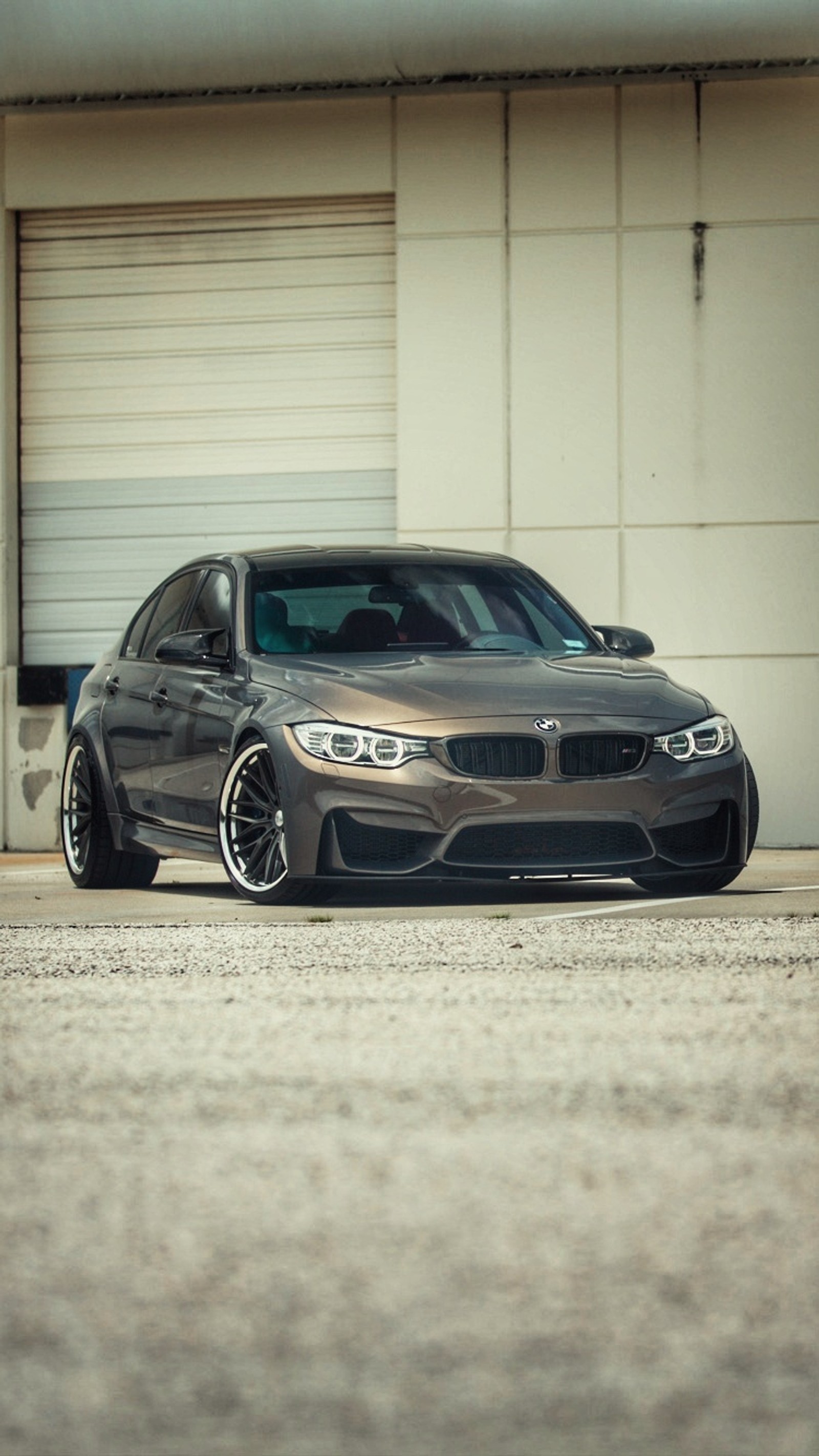 Coche bmw arafed estacionado frente a una puerta de garaje (coche, bmw, f80, m3, sedán)