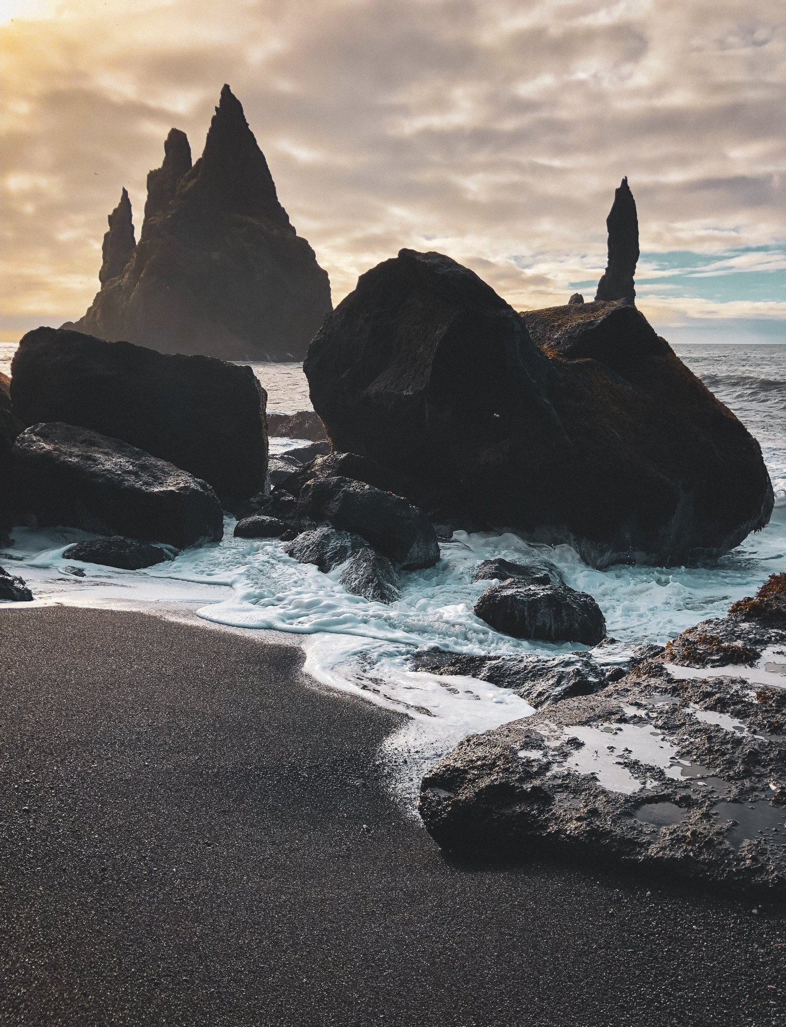 Hay una persona de pie sobre una roca junto al océano (naturaleza, playa, atardecer, escenario, olas)