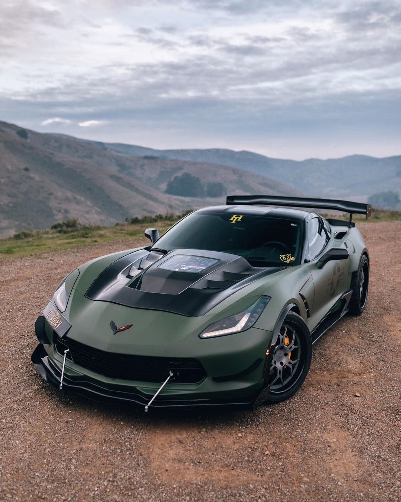 A close up of a green sports car parked on a dirt road (dodge, viper)