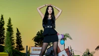 Joy from Red Velvet showcasing a confident pose against a vibrant background, embodying the energy of K-pop and the spirit of "Queendom.