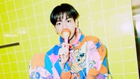 Baekhyun con atuendo colorido disfrutando de una manzana de caramelo